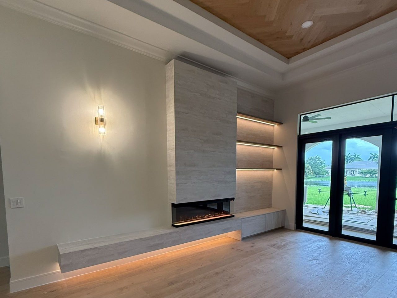 Webb Residence fireplace wall with integrated custom millwork, shelving, lighting, and cabinetry