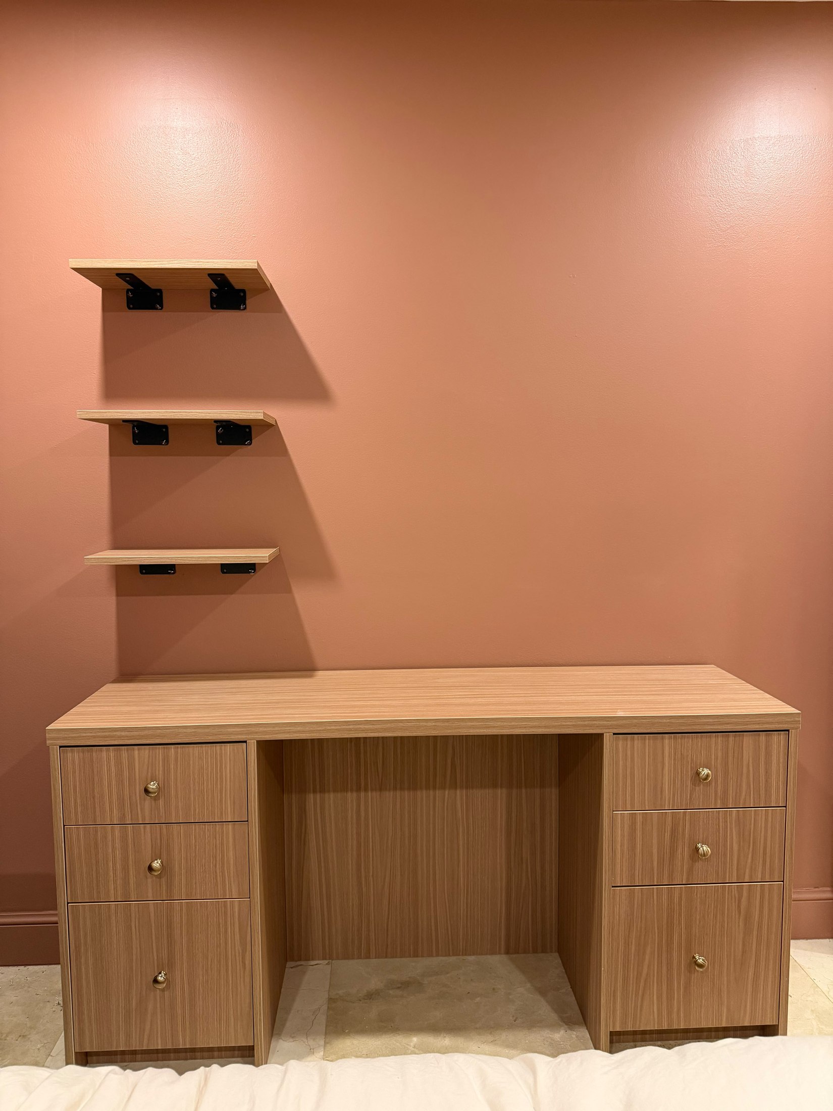 Custom built-in vanity with warm wood cabinetry and floating shelves