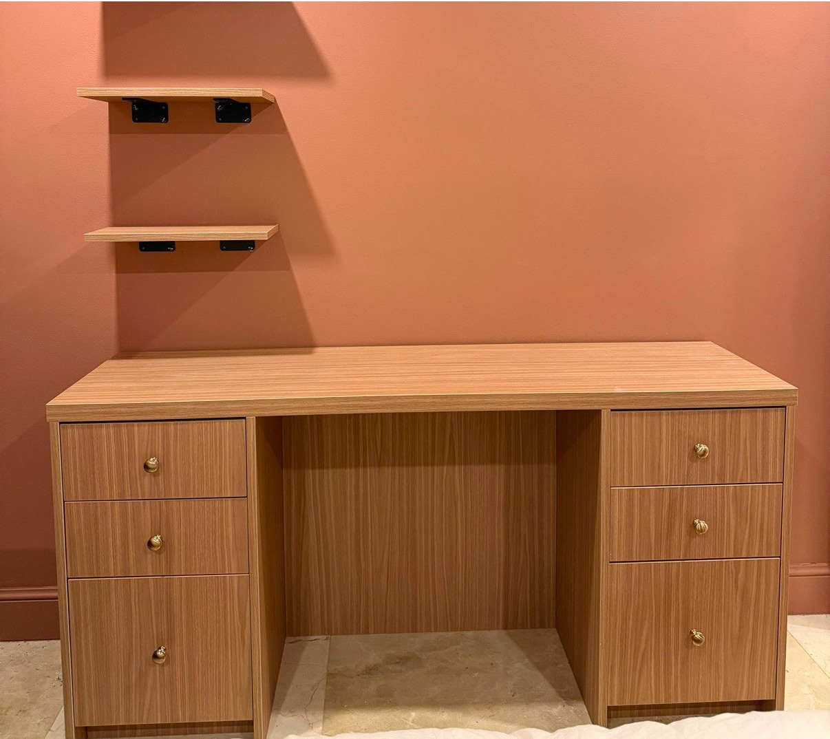 Completed built-in vanity with warm wood cabinetry and floating shelves